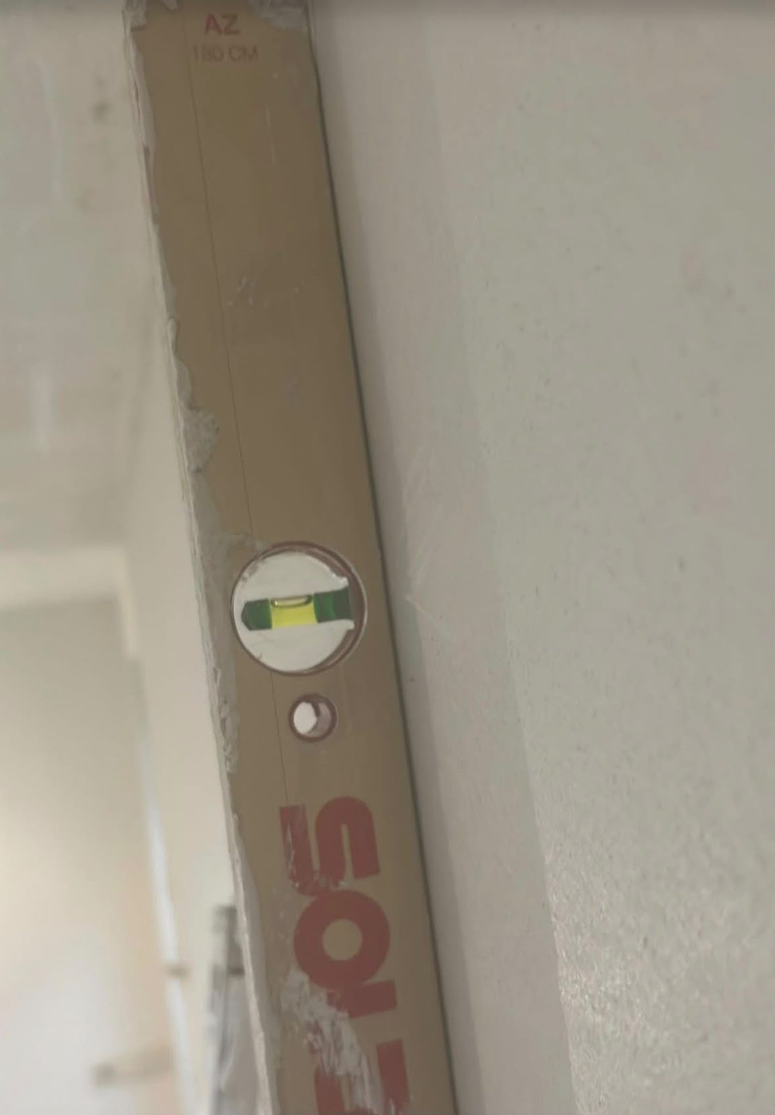 Waterpas tegen een strak gestucte wand
